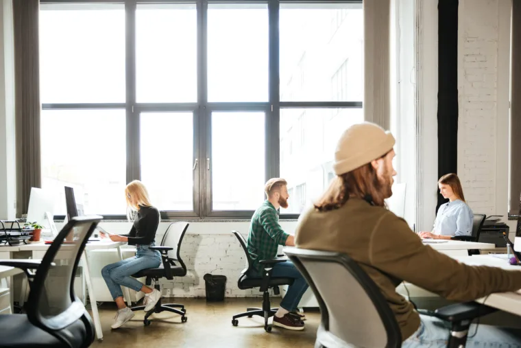colleagues-work-office-using-computers-looking-aside
